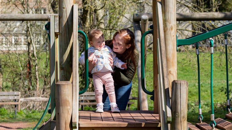 Family visitors using the playground on a sunny spring day, Coventry Charterhouse, Estate, Warwickshire